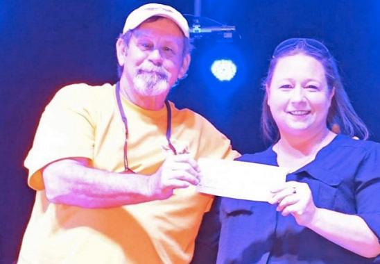 Bill Taber of Biker Rallies of Texas presents a donation check to Amy Ouellette, CEO of the local Boys &amp; Girls Club of Bandera County at the conclusion of their 20th anniversary of Thunder in the Hill Country at Mansfield Park. Courtesy Photo