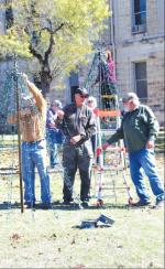 BULLETIN PHOTO/Bill Pack                      Mike Lloyd, left, Marcus Kaspar, center, and Grady Desmuke adjust lights on one of the Christmas trees on the Bandera County Courthouse grounds on Saturday, Nov.                                23, wh